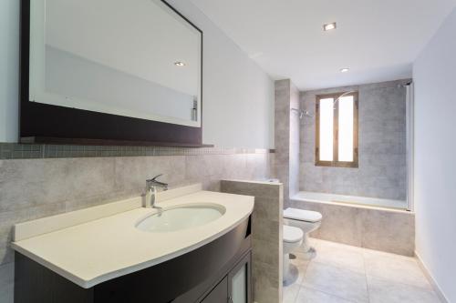 米尼奥Housingcoruña Apartamento Playa Miño 02的一间带水槽、卫生间和镜子的浴室