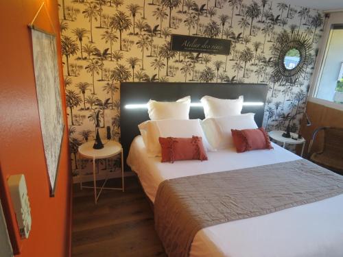 阿维尼翁Hôtel Kyriad Cap Sud的一间卧室设有一张大床和壁纸墙
