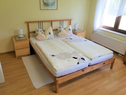 大舍瑙Appartement am Teich的一间卧室配有一张带枕头的木床