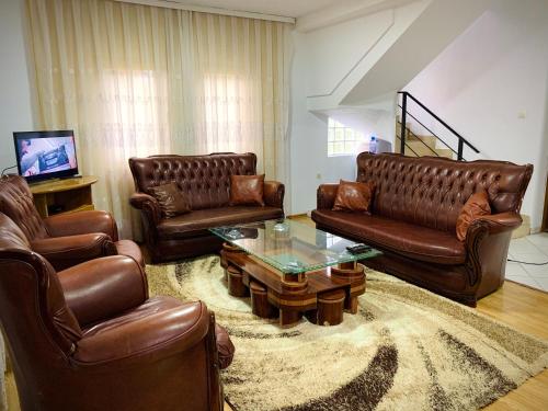 佩奇Villa Liqenat的客厅配有真皮沙发和茶几