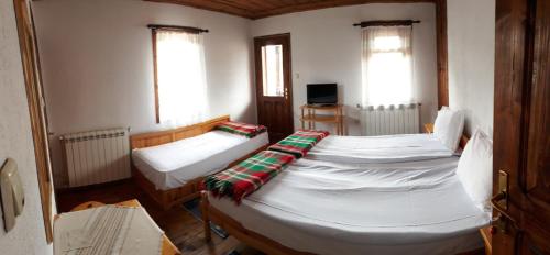 科普里夫什迪察Sarafova Guest House的客房设有两张床、一台电视和两个窗户。