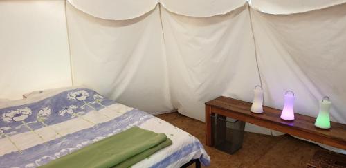 讷维克Tipi - Camping Le Soustran的一间卧室配有一张床和一张带两个蜡烛的桌子。