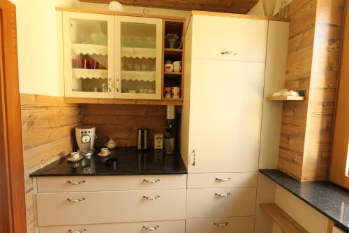 DamtschachChalet Damtschach的厨房配有白色橱柜和黑色台面