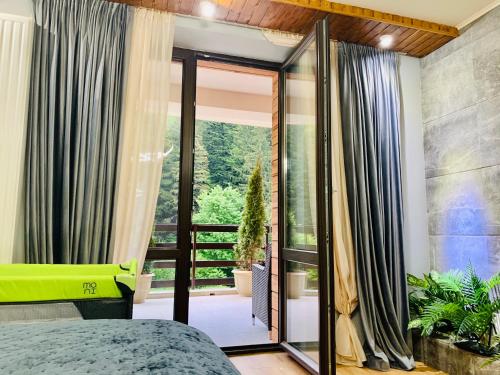 波亚纳布拉索夫Maya Luxury Residence的一间卧室设有一张床和一个大型玻璃门