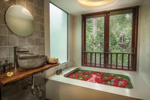 乌布Merak Village by Prasi的浴室配有鲜花盛开的浴缸。