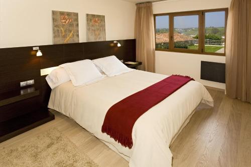桑提亚纳德玛佩特拉城堡公寓的一间卧室设有一张大床和大窗户