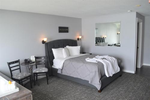林肯市Starfish Manor Oceanfront Hotel的卧室配有一张床和一张桌子及椅子