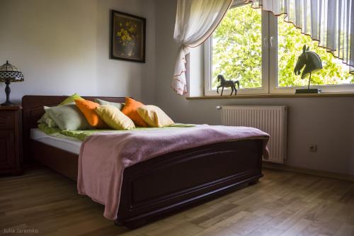 伊拉华Leśne Zacisze的卧室配有带枕头的床铺和窗户。