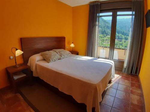 埃尔阿雷纳尔洛斯莫林尼罗斯乡村酒店的一间卧室设有一张大床和一个大窗户