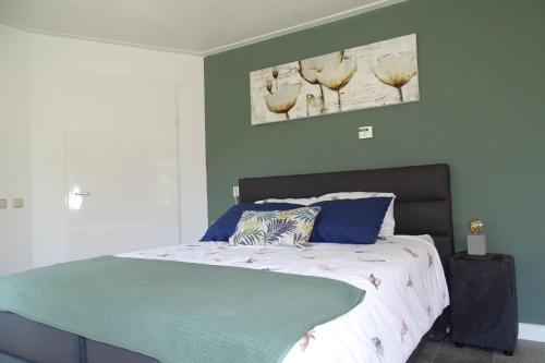 LoerbeekBeekse Brink的一间卧室配有一张带绿色墙壁的床