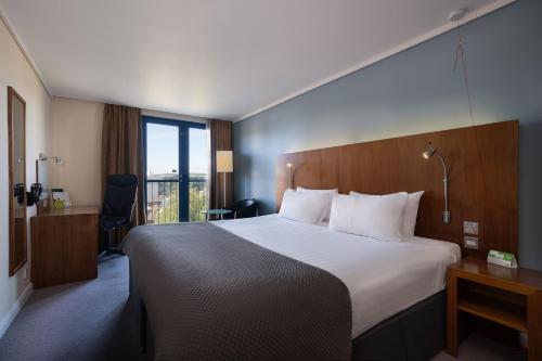 伦敦假日伦敦卡姆登洛克酒店的酒店客房设有一张大床和一个阳台。