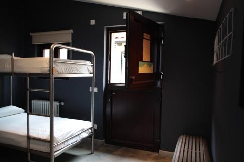 纳隆河畔穆罗斯Casa Carmina Hostel的带两张双层床和一扇门的房间