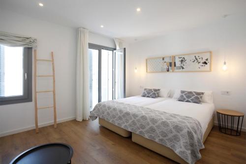 阿尔塔Petit Artà的白色的卧室,配有床和梯子