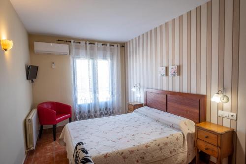 阿尔德亚达维拉德拉里韦拉拉加拉－阿瑞贝斯酒店的一间卧室配有一张床和一张红色椅子