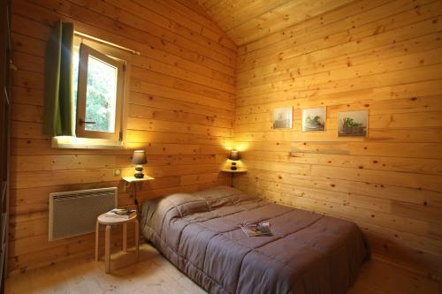 Salignac Eyvigues"Les Collines d'Eyvigues"的小木屋内一间卧室,配有一张床