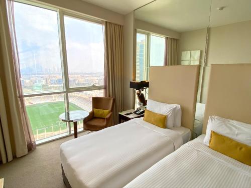 阿布扎比中央阿尔曼哈尔罗塔纳酒店的酒店客房设有两张床和大窗户。