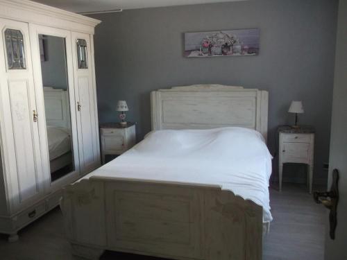 Traubach-le-BasGite les Rosiers的卧室配有白色的床和镜子