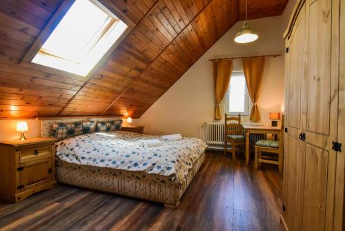 伦布尔克Pension Dymník的卧室设有一张木制天花板上的大床