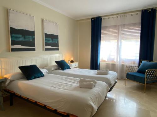 CabanillasLas Casas de Sofía的配有蓝色窗帘的客房内的两张床