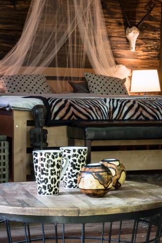 兹林Glamping Safari - Africa House的床上的桌子上放着两杯