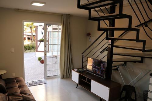 马塞利努拉穆斯POUSADA GERMÂNICA的客厅设有螺旋楼梯和沙发