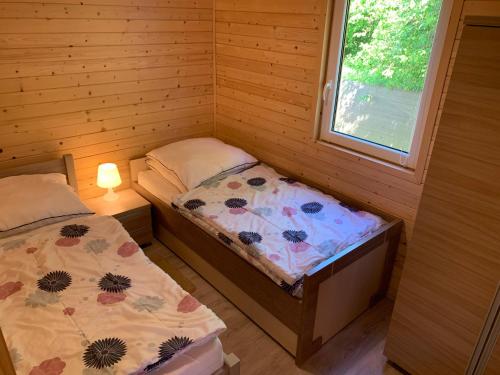 尤斯托尼莫斯基Domki Letniskowe U Kasi的一间小卧室,配有两张床和窗户