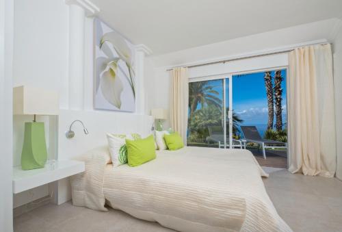 拉马坦萨德亚森特霍Jardin de la Paz的白色的卧室设有床和大窗户