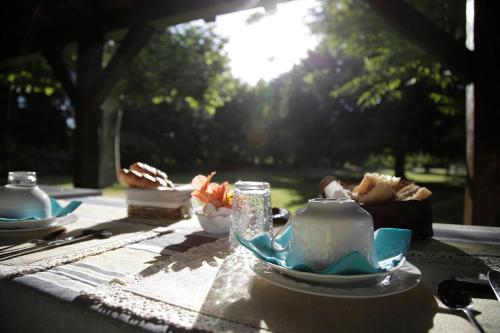 MazéRive Gauche - Chambres d'hôtes en bord d'Authion的茶壶,茶杯和盘子的桌子
