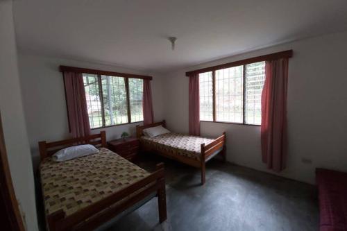 图里亚尔瓦The Calm House的一间卧室设有两张床和两个窗户。