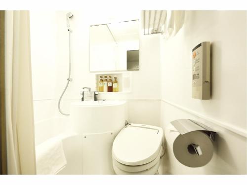 仙台Sendai Business Hotel Ekimae的白色的浴室设有卫生间和水槽。