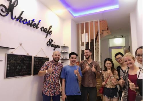 胡志明市H Best Hostel Cafe SaiGon的一群人在一个房间里摆着一张照片