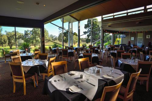 伦马克Renmark Country Club的用餐室设有桌椅和窗户。