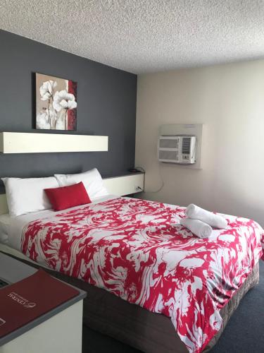 埃默拉尔德Emerald Central Hotel Official的一间卧室配有一张带红白毯子的床