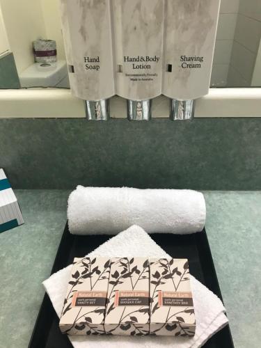 埃默拉尔德Emerald Central Hotel Official的浴室提供毛巾和两卷卫生纸