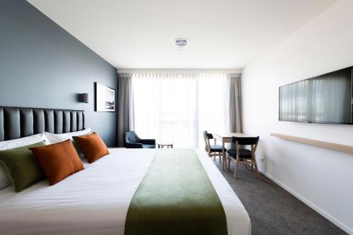 堪培拉阿多比金斯顿酒店的酒店客房设有一张大床和一张桌子。