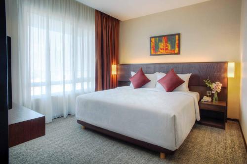 吉隆坡富丽华国际管理大酒店的卧室配有带红色枕头的大型白色床