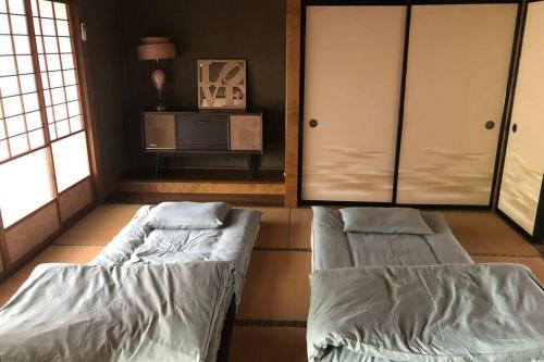 Yokozeまるまる貸切一軒家 ゆっくり過ごせる民泊 武甲ステイ的客房设有两张床、一张桌子和窗户。