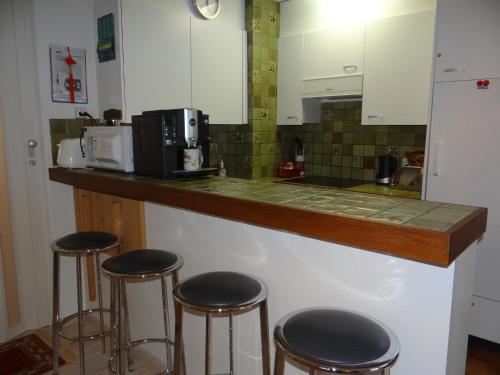 英格堡Apartment Zügstrasse 4 by Interhome的厨房配有带四把吧台凳的吧台