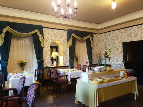 利敦瓦纳皇室温泉酒店的一间用餐室,配有两张带食物盘的桌子