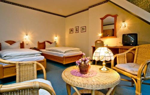 哈尔伯施塔特格鲁登堡酒店的酒店客房设有两张床和一张带台灯的桌子。