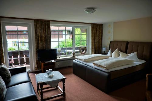 奥伯斯特多夫卡尼利比里亚酒店的一间卧室配有一张床、一张沙发和窗户。