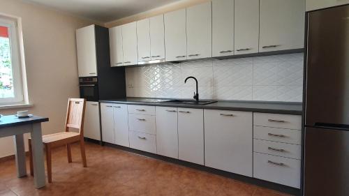 特伦DoTleń Villa的厨房配有白色橱柜、水槽和桌子