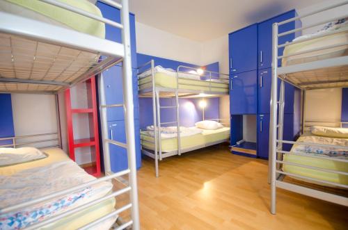卢布尔雅那H2O旅馆的一间设有四张双层床和蓝色墙壁的客房