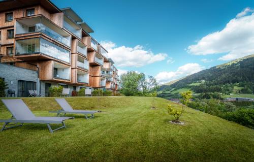 斯拉德明Sun Lodge Schladming by Schladming-Appartements的一座带两张躺椅的草木山丘建筑