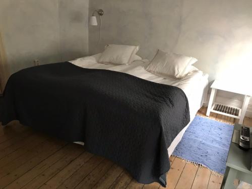 隆德布鲁纽斯住宿加早餐酒店的一张带黑色毯子和枕头的床