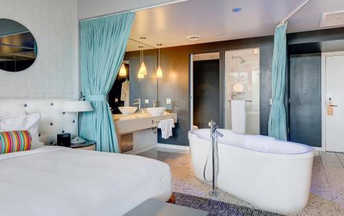 斯科茨浩谷酒店的一间卧室配有一张床、一个浴缸和一个水槽