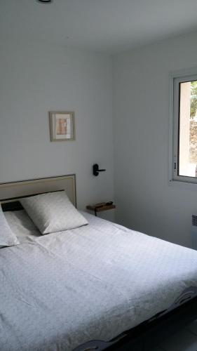 尚皮涅Le 10 Bis的卧室内的一张白色床,设有窗户
