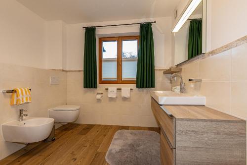 米滕瓦尔德Ferienhaus STOARÖSERL的一间带水槽和卫生间的浴室以及窗户。