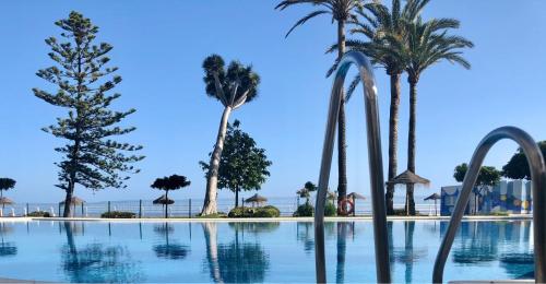 多列毛利诺斯Castillo Santa Clara的一座棕榈树和蓝天游泳池