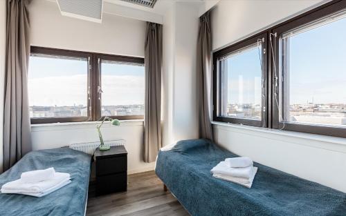 赫尔辛基Sky Hostel Helsinki的带2扇窗户的客房内的2张床